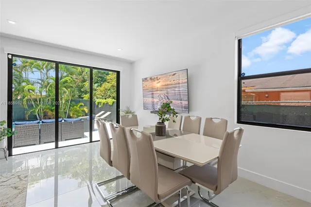 a view of a dining room with furniture large windows and wooden floor