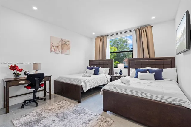 a bedroom with two beds and a window