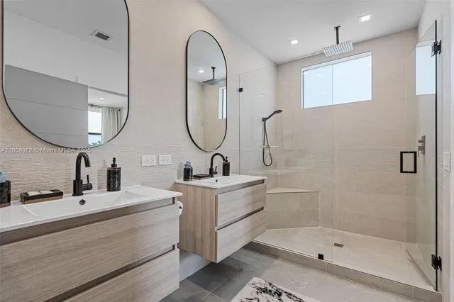 a bathroom with a double vanity sink mirror and shower