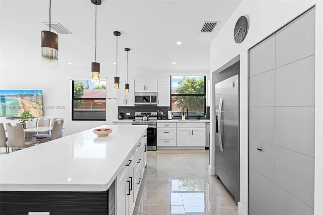 a kitchen with stainless steel appliances a refrigerator sink and microwave
