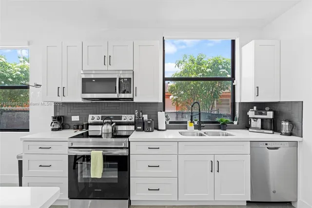 a kitchen with white cabinets and white appliances
