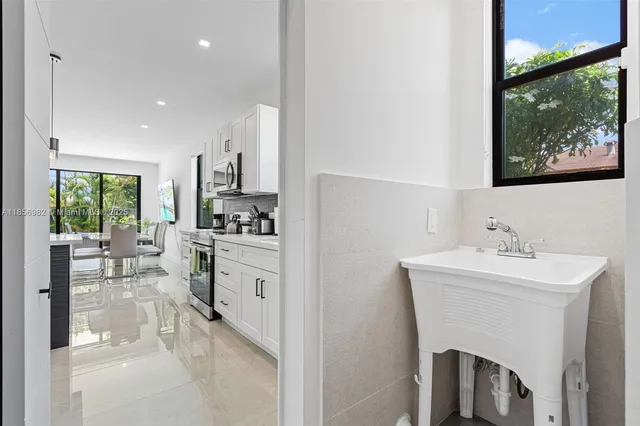 a living room with stainless steel appliances kitchen island furniture and a window