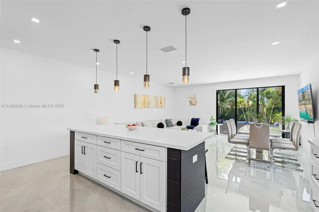 a open kitchen with stainless steel appliances kitchen island a white counter space a sink and a window