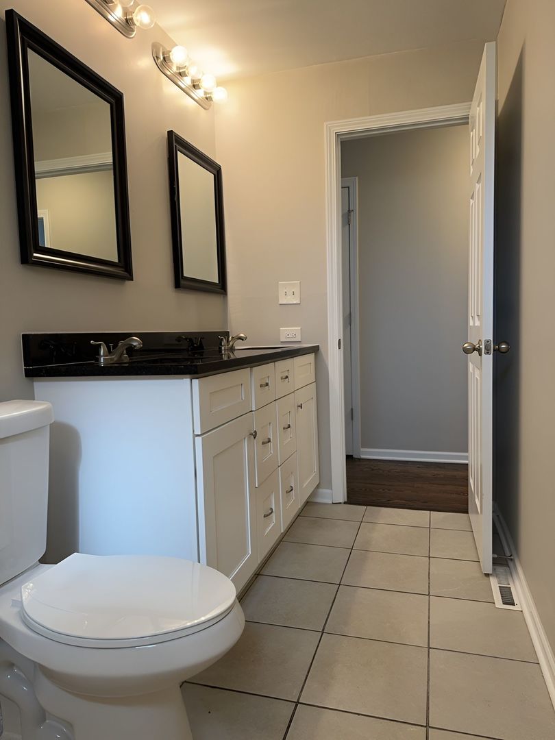 533 Surryse Road Lake Zurich, IL 60047 - Photo 32 of 51 a bathroom with a toilet a sink a mirror and vanity