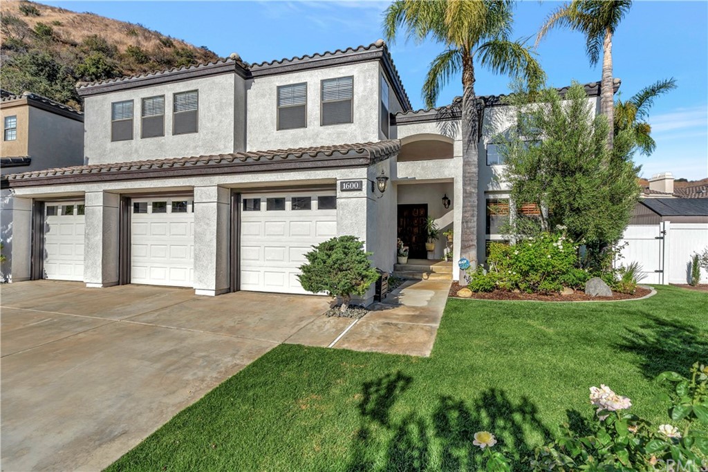 1600 Canyon Crest Circle Corona, CA 92882 - Photo 2 of 74 a front view of a house with a garden