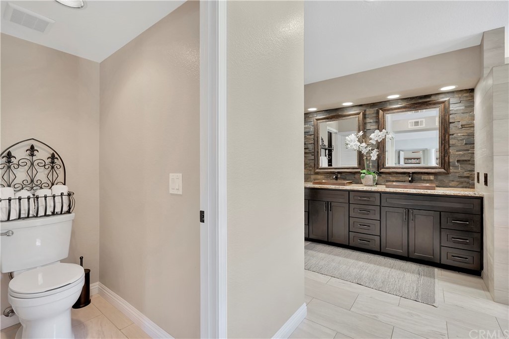 1600 Canyon Crest Circle Corona, CA 92882 - Photo 63 of 74 a bathroom with a granite countertop sink a toilet and a mirror