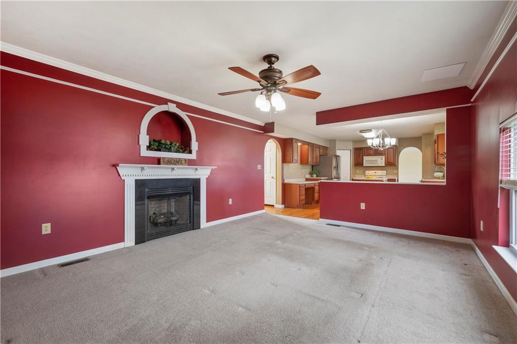 208 Commodore Drive McDonald, PA 15057 - Photo 14 of 36 a view of an empty room with a fireplace and a ceiling fan