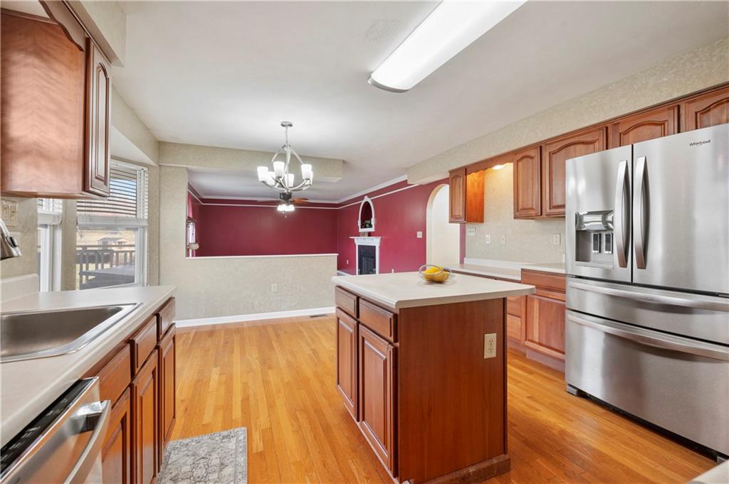 208 Commodore Drive McDonald, PA 15057 - Photo 5 of 36 a kitchen with stainless steel appliances granite countertop a refrigerator a sink dishwasher a stove and white countertops with wooden floor