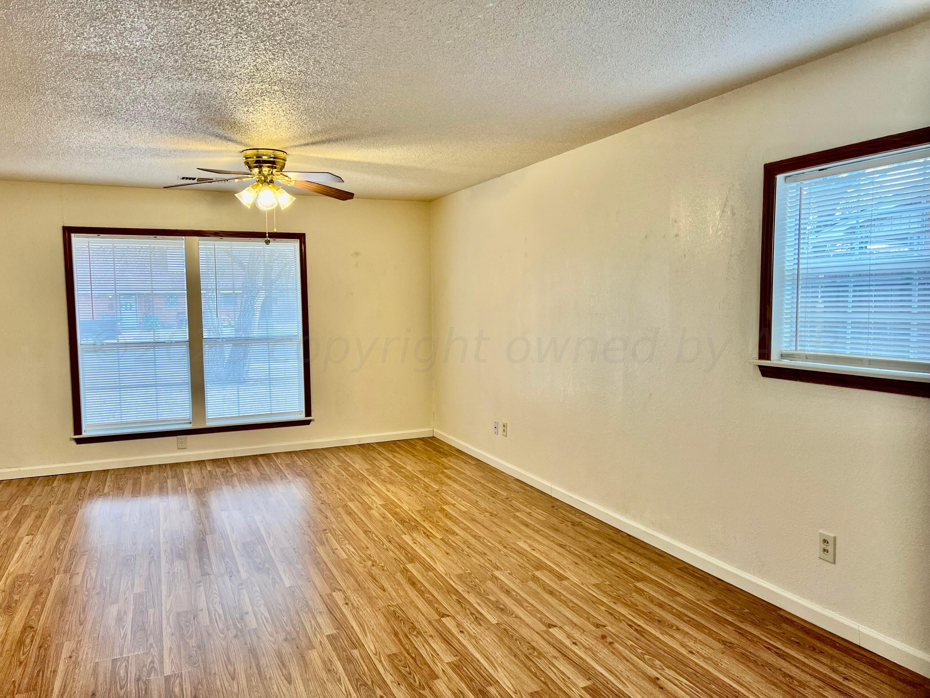 4600 Southwest 38th Avenue Amarillo, TX 79109 - Photo 13 of 19 a view of an empty room with wooden floor and a window