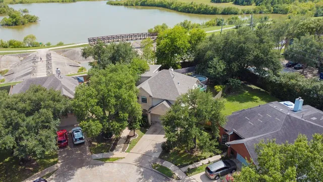 an aerial view of a house with a garden and lake view