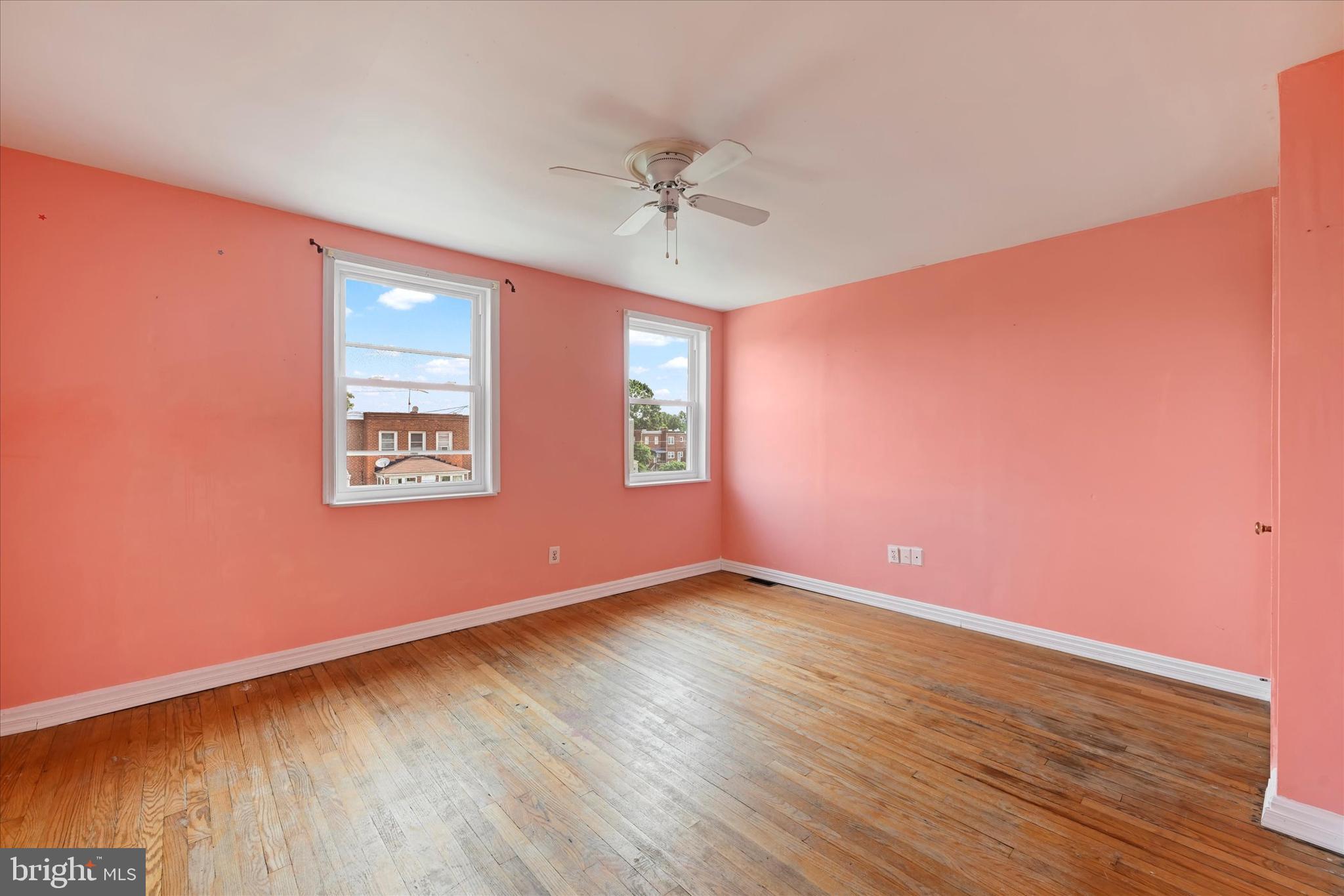 8059 Gray Haven Road Dundalk, MD 21222 - Photo 11 of 19 an empty room with wooden floor chandelier fan and windows