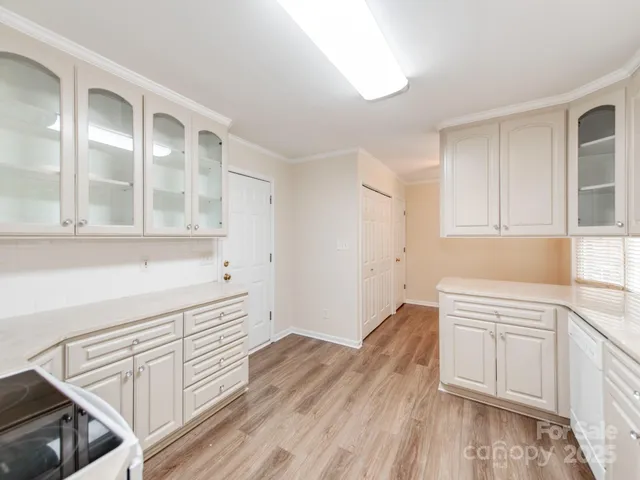 a view of a kitchen with wooden floor and cabinets
