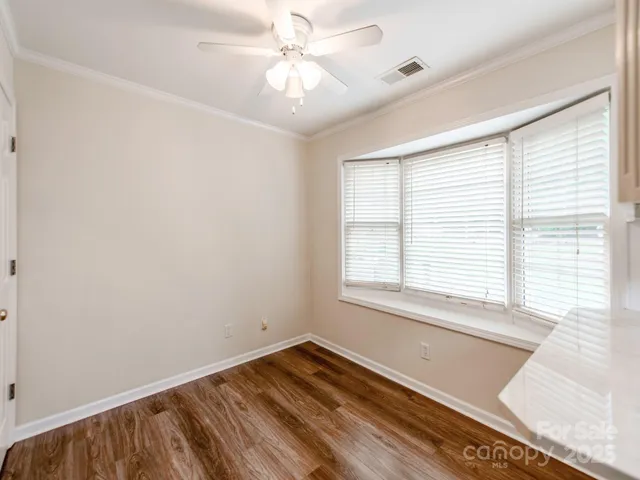 a view of an empty room with a window and a ceiling fan