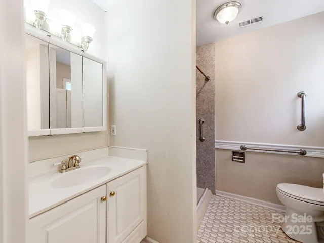 a bathroom with a sink a toilet and shower