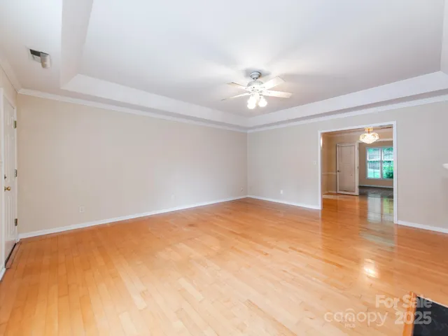 a view of empty room with wooden floor