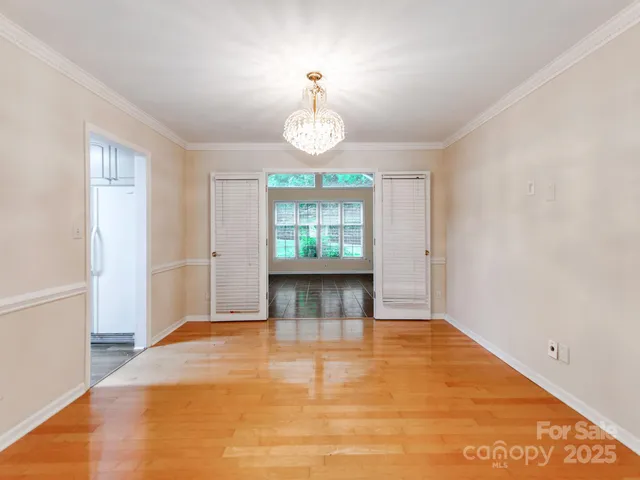 a view of empty room with window and wooden floor