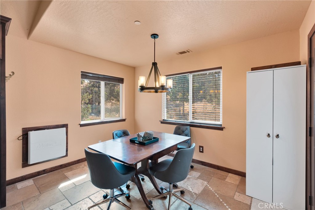 7635 Desert Front Road Wrightwood, CA 92397 - Photo 12 of 60 a dining room with furniture a chandelier and wooden floor