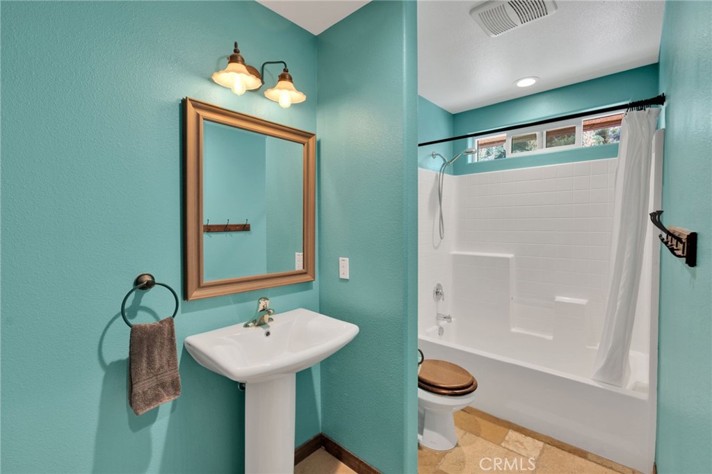 7635 Desert Front Road Wrightwood, CA 92397 - Photo 16 of 60 a bathroom with a sink a toilet and shower