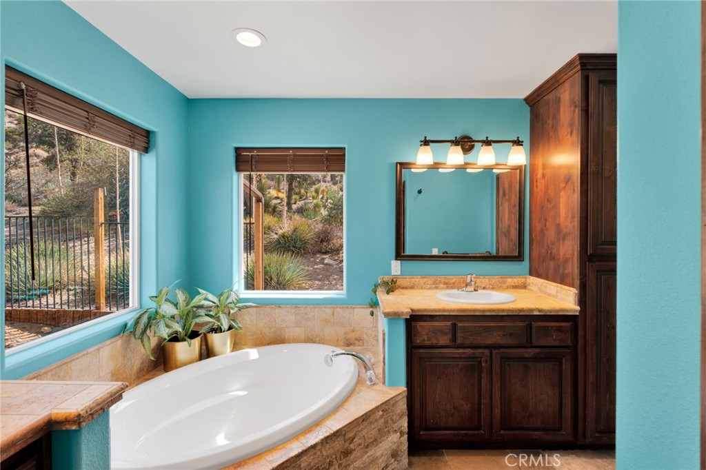 7635 Desert Front Road Wrightwood, CA 92397 - Photo 19 of 60 a bathroom with a tub sink and mirror