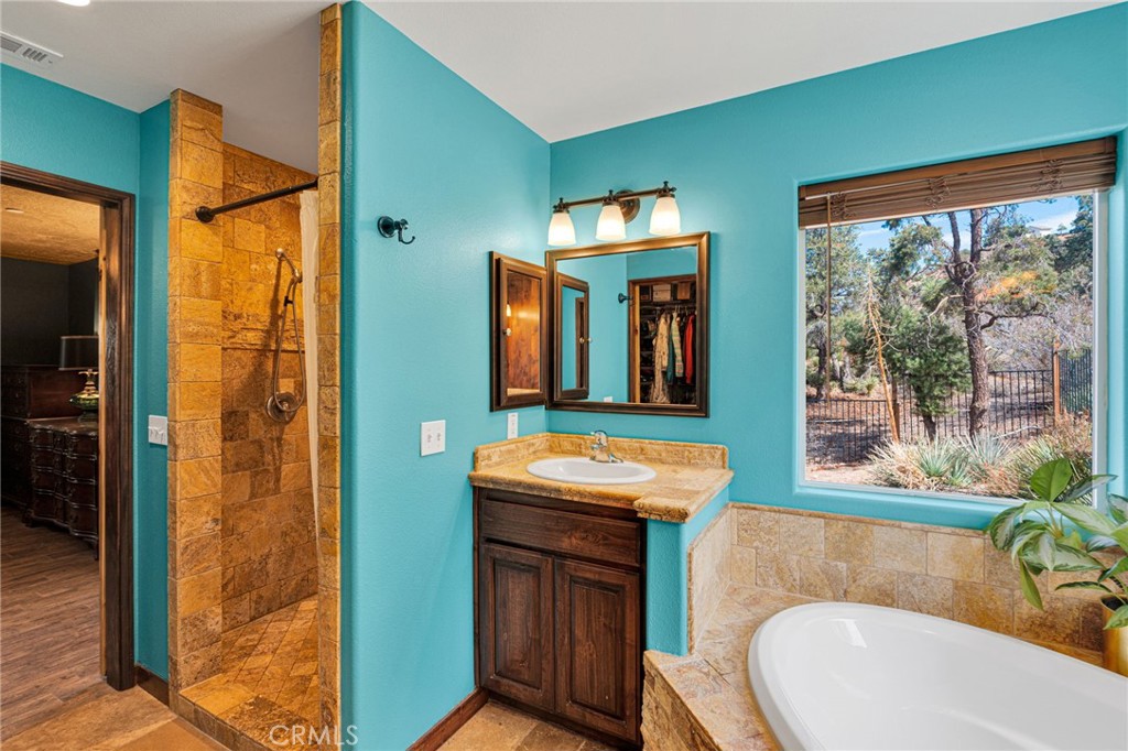 7635 Desert Front Road Wrightwood, CA 92397 - Photo 21 of 60 a bathroom with a sink a mirror and a bathtub