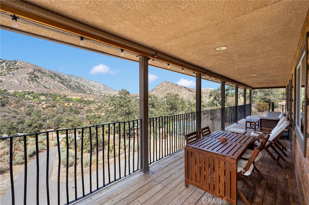 7635 Desert Front Road Wrightwood, CA 92397 - Photo 26 of 60 a balcony with wooden floor table and chairs