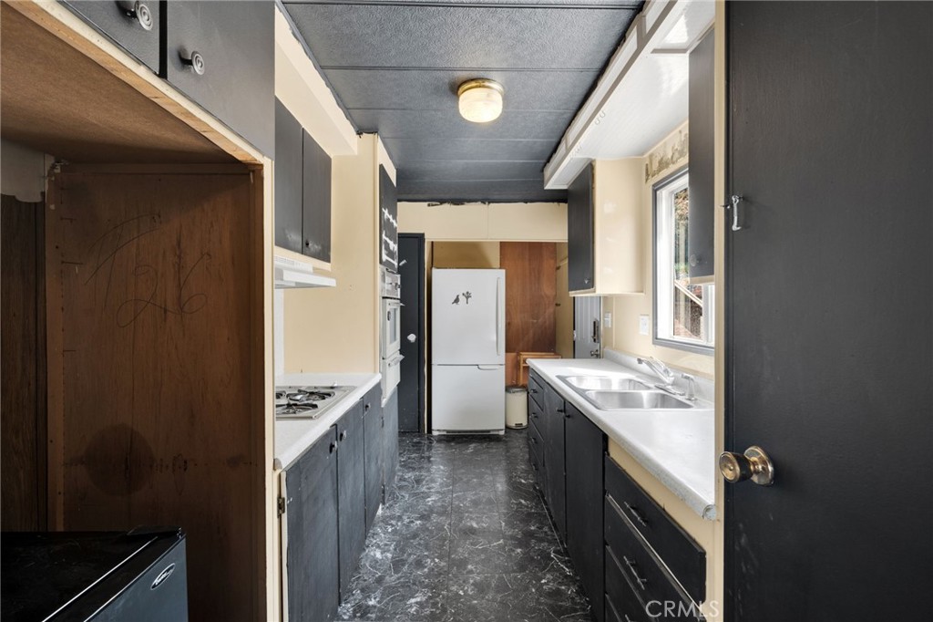 7635 Desert Front Road Wrightwood, CA 92397 - Photo 36 of 60 a kitchen with stainless steel appliances granite countertop a stove a refrigerator and a sink