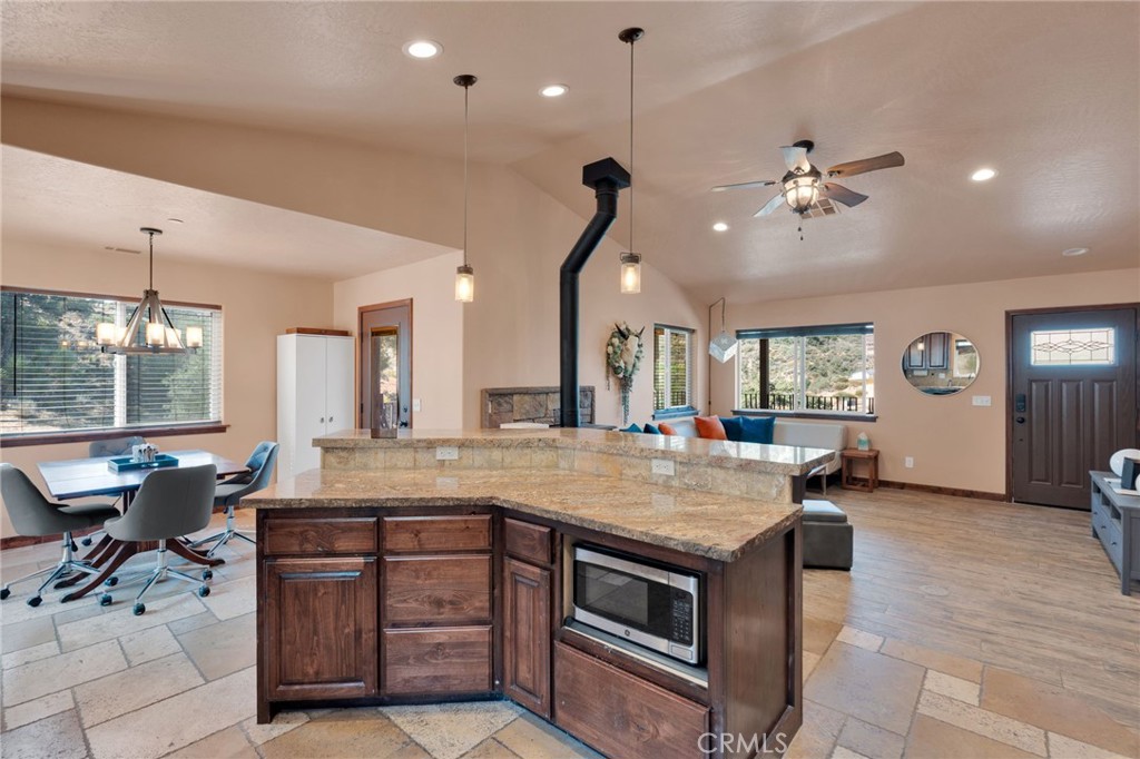 7635 Desert Front Road Wrightwood, CA 92397 - Photo 9 of 60 a kitchen with a stove a counter space dining table and chairs