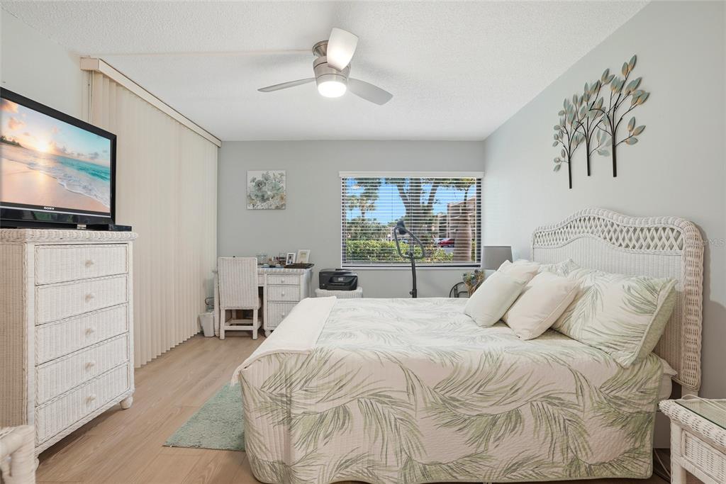 12300 Vonn Road, Unit 7104 Largo, FL 33774 - Photo 23 of 41 a bedroom with a large bed and a flat tv screen on dresser