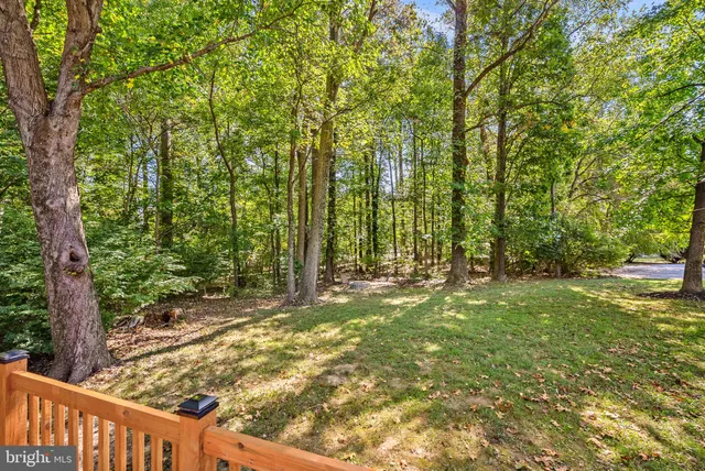 a view of a house with table and chairs under an umbrella