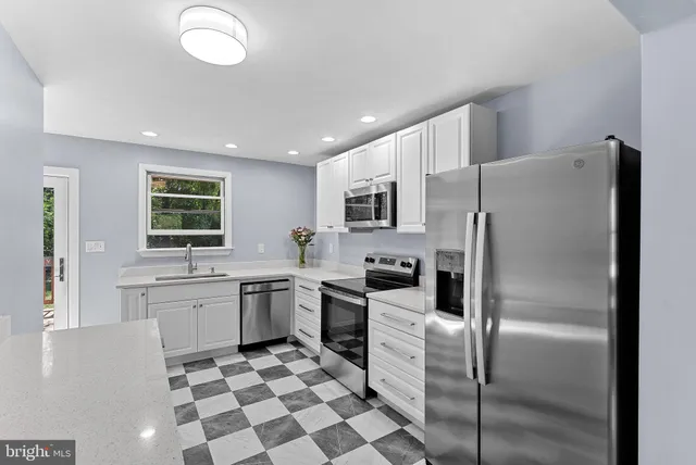 a kitchen with stainless steel appliances granite countertop a refrigerator sink and stove