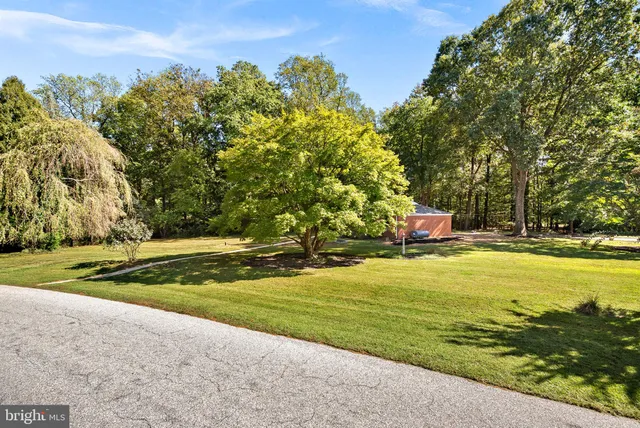 a backyard of a house with lots of green space and fountain