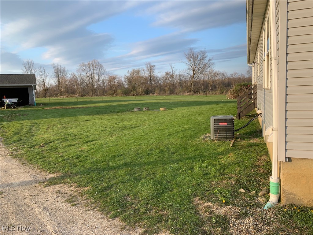 10677 Moss Road Lodi, OH 44254 - Photo 11 of 34 View of grassy yard featuring central AC unit and an outbuilding