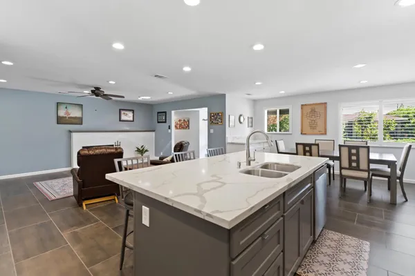 a large kitchen with kitchen island a sink table and chairs