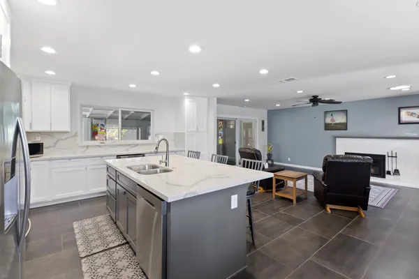 a kitchen with a sink dining table and chairs