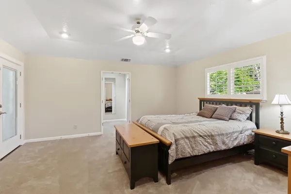 a spacious bedroom with a bed and a chandelier