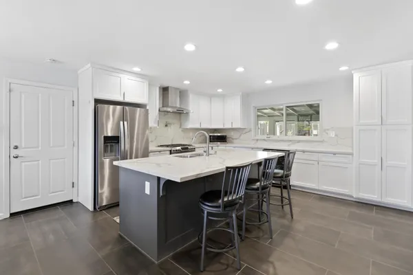 a kitchen with a dining table chairs and refrigerator