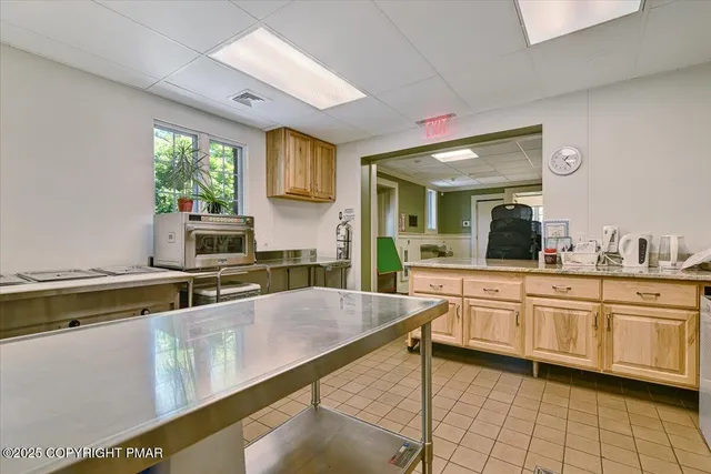 a large kitchen with kitchen island a large counter space appliances and a window