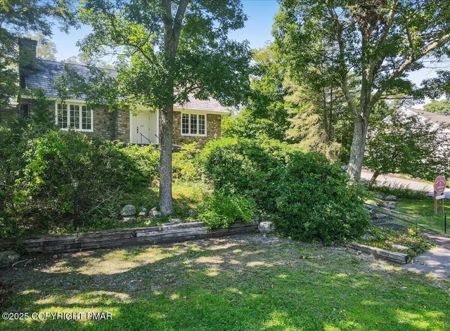 a front view of a house with a yard and trees