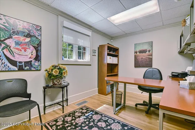 a view of a workspace with furniture and a window