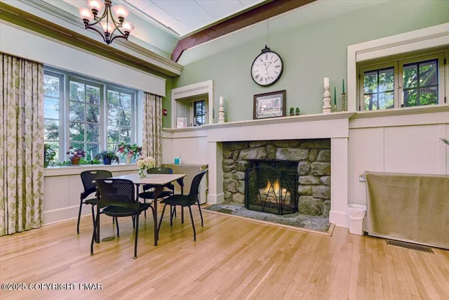 a dining room with furniture a fireplace and a large window