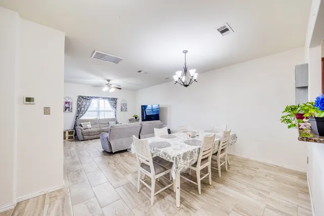 a view of a dining room with furniture and chandelier