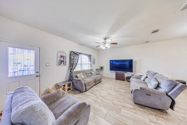 a living room with furniture and a ceiling fan