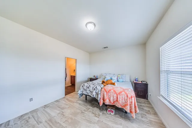 a bed sitting in a bedroom next to a window