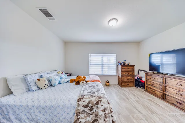 a bedroom with furniture and a flat screen tv