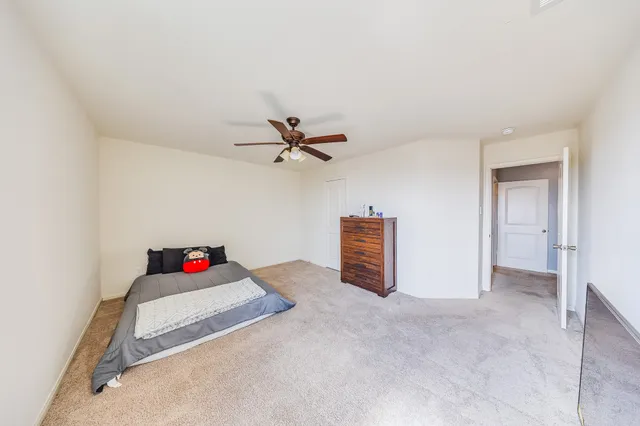 a living room with hard wood floor and a ceiling fan
