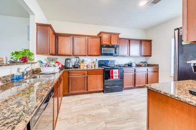 a kitchen with stainless steel appliances granite countertop a stove sink and cabinets