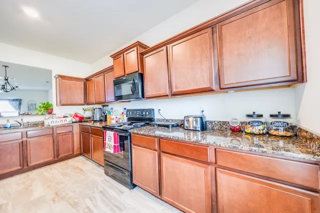 a kitchen with stainless steel appliances granite countertop a stove and cabinets