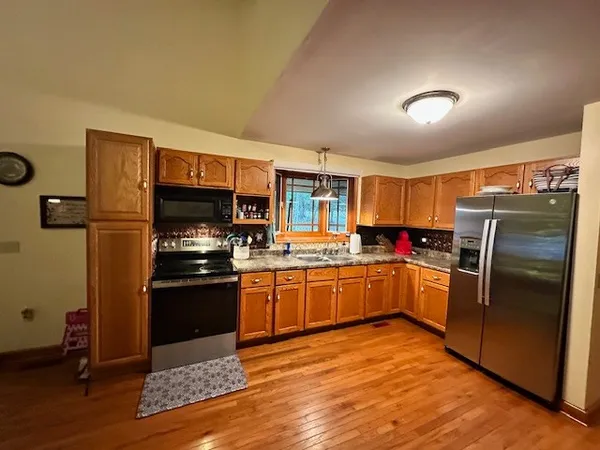 a kitchen with granite countertop stainless steel appliances and wooden cabinets