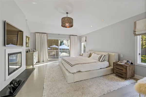 a spacious bedroom with a bed and a flat tv screen