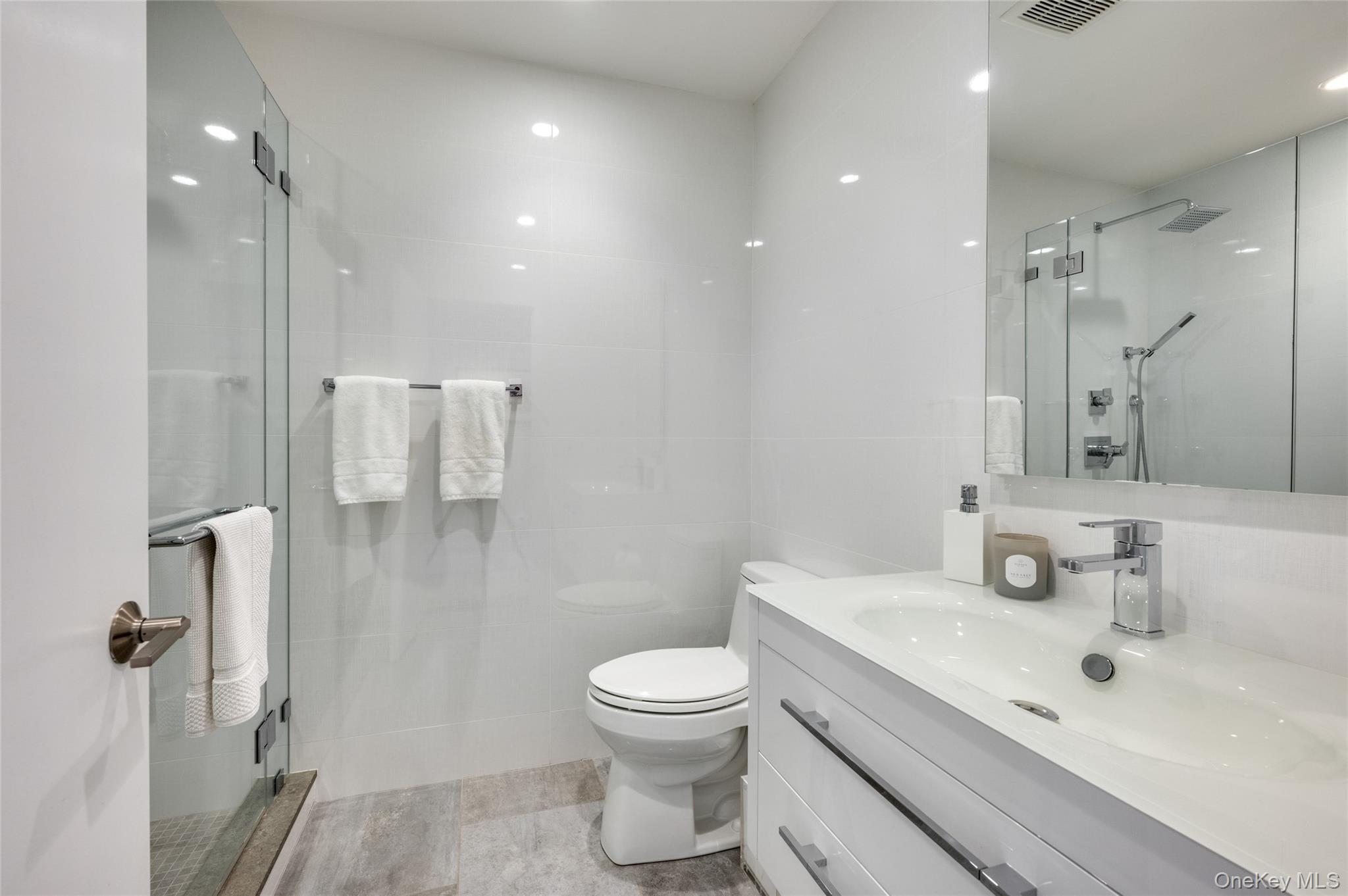 6 Bridle Path Westhampton Beach, NY 11978 - Photo 16 of 33 a bathroom with a sink toilet a shower and a mirror